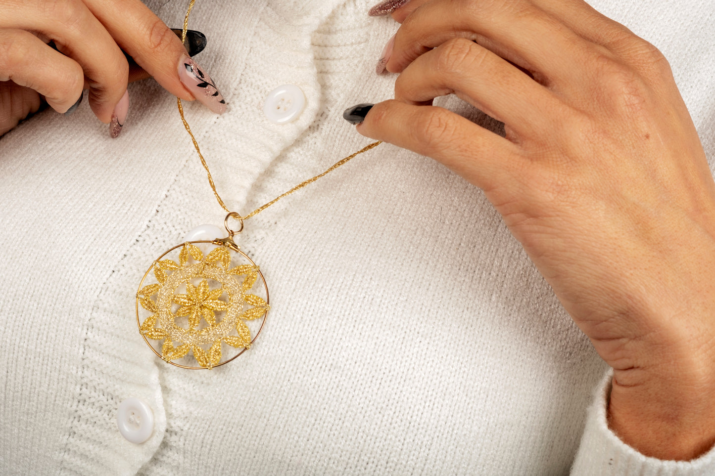 Ciondolo in merletto a tombolo oro metallizzato con punto luce