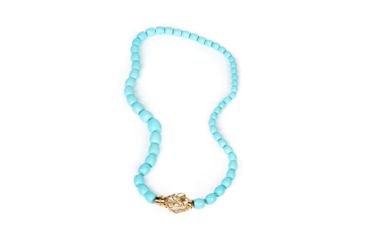 Collana in pasta di turchese con chiusura scultura in oro giallo