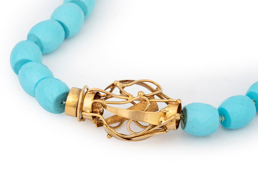 Collana in pasta di turchese con chiusura scultura in oro giallo
